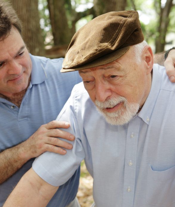 Senior man in failing health and his worried middle-aged son.  Focus on Senior man.